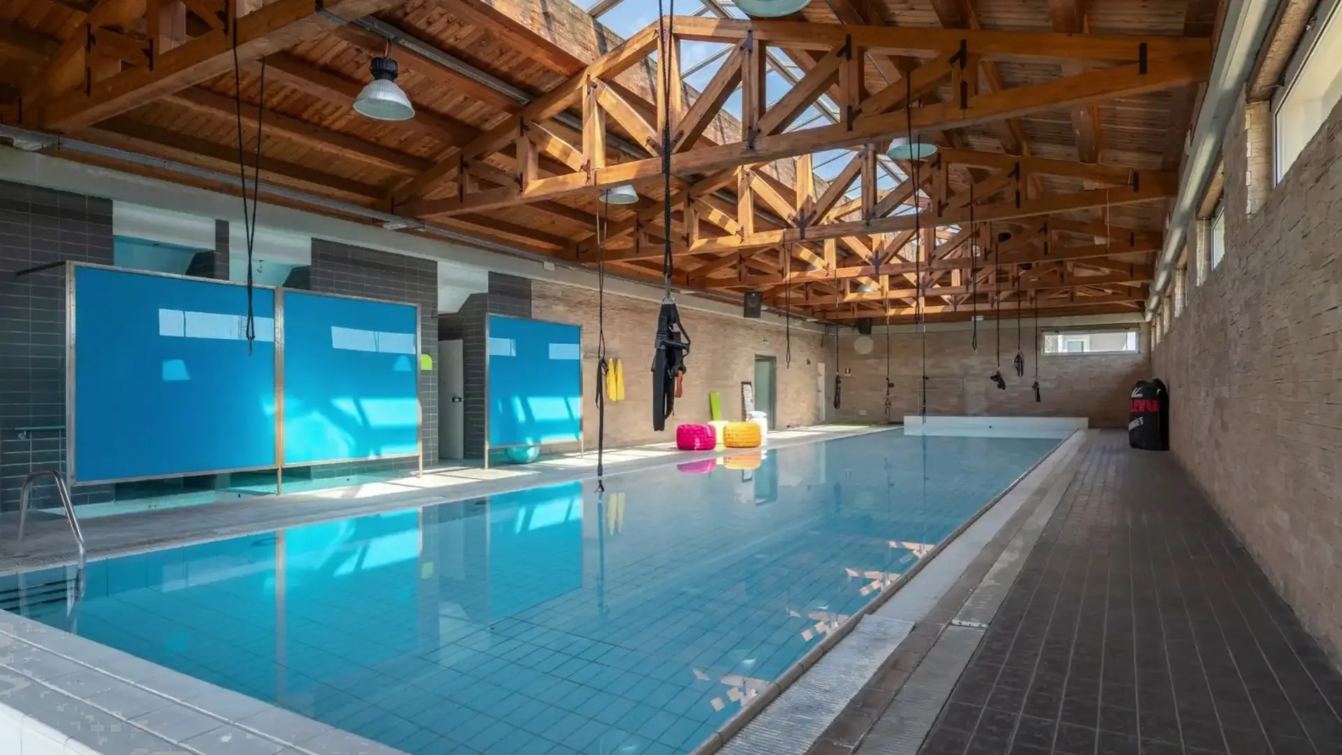 Piscina interna con copertura e travi in legno